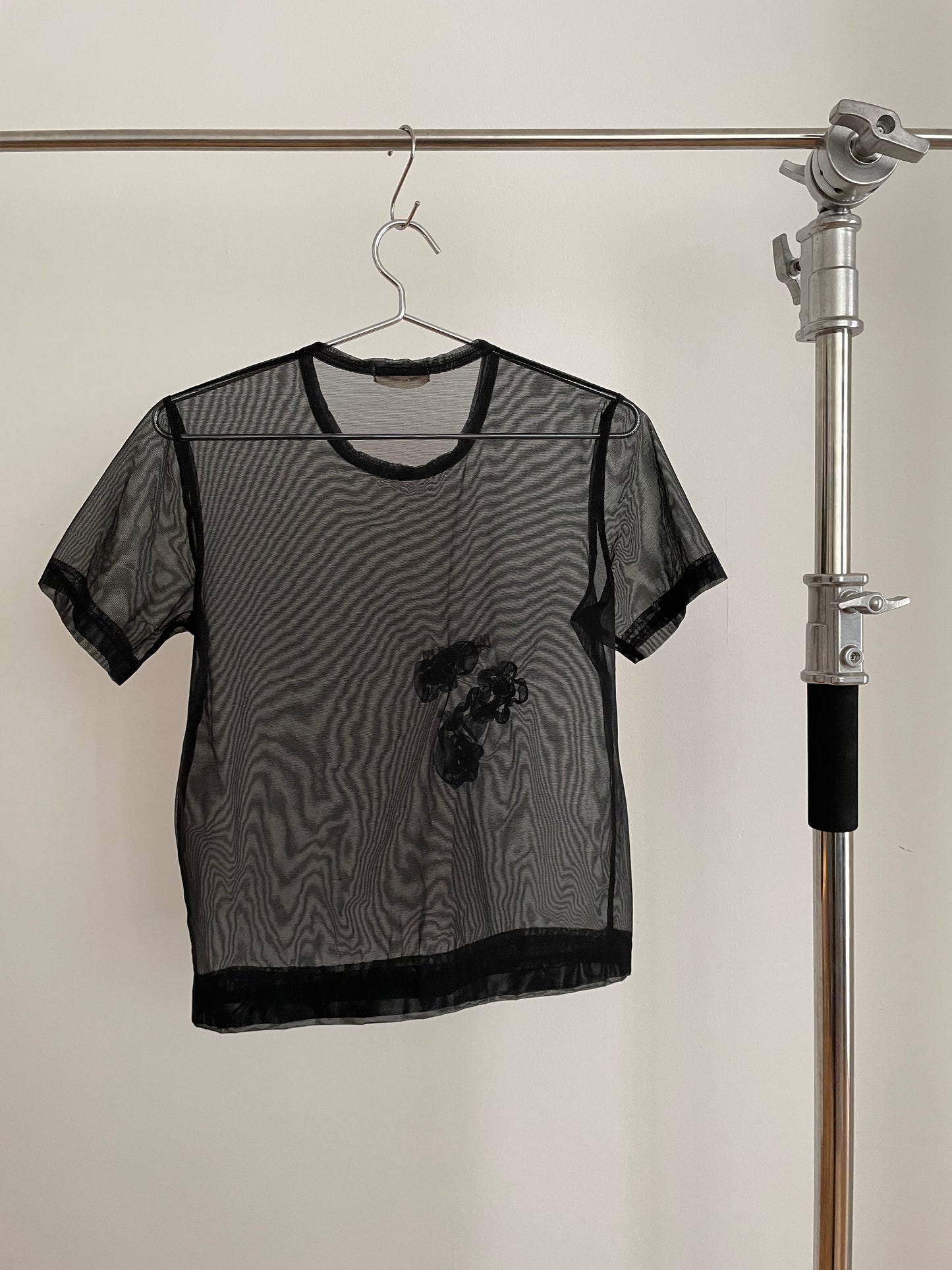 Back view of vintage womens Comme des Garçons black short sleeve mesh top with rosette appliqués