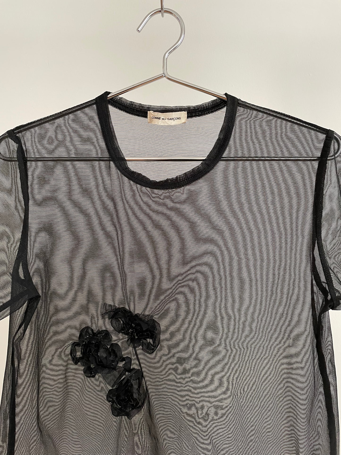 Detail view of vintage womens Comme des Garçons black short sleeve mesh top with rosette appliqués